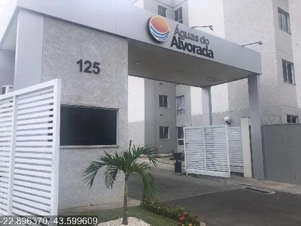 Apartamento no Condomínio Residencial Águas do Alvorada com fachada cinza e portaria com portão branco em área urbana