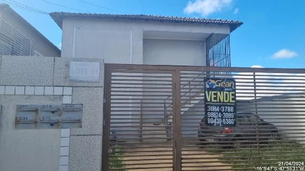 Apartamento branco com portão de ferro marrom em condomínio residencial pequeno com 2 andares e área na frente