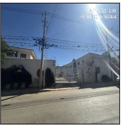 Apartamento branco no Condomínio Residencial Blend com muro e portão de entrada visíveis em dia ensolarado