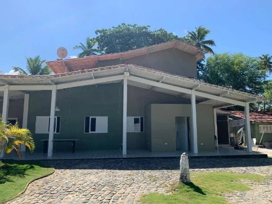 Apartamento ocupado com fachada cinza, varanda coberta e área externa com gramado e calçada