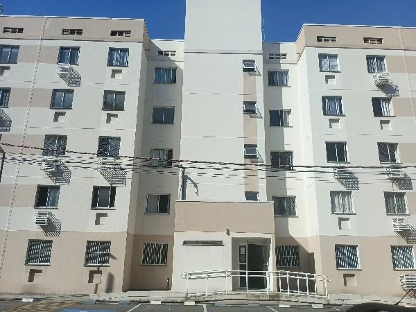 Apartamento amplo com fachada bege e branca em condomínio residencial com área de estacionamento frontal